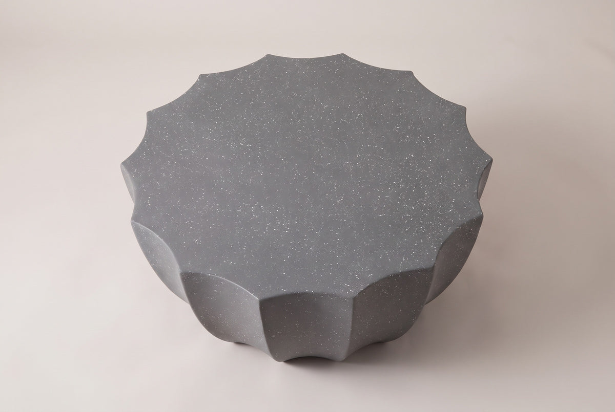 The Ribera coffee table seen from above: the flat speckled gray top with fourteen points around its scalloped edge