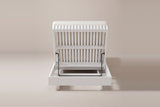 The Riesi chaise from behind the head end: the slatted back raised on a black metal prop bar above the open white head box