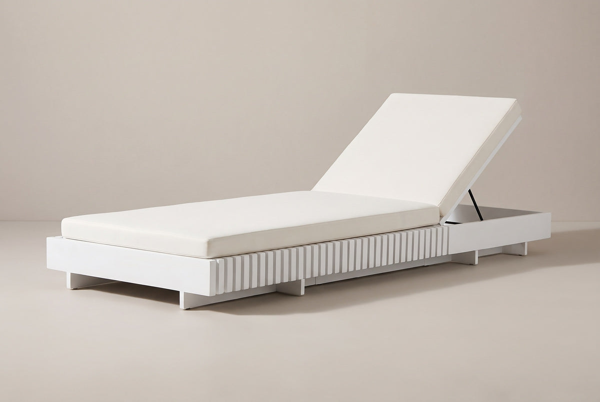 The Riesi white acacia chaise lounge with its ivory cushion, three-quarter view from the foot end on a light studio backdrop