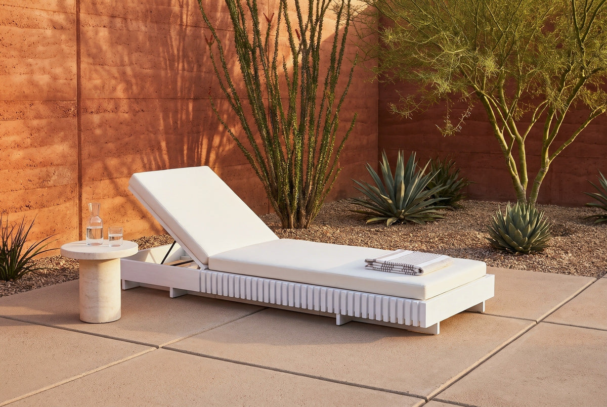 Riesi white acacia chaise lounge in a Tucson desert courtyard at golden hour, a terracotta rammed-earth wall, ocotillo and agave behind (side table not included)