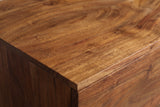 Close-up of the amber-brown acacia on the Rionero sideboard: bold flowing grain with golden highlights running to a square edge