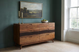 Rionero acacia sideboard with brass candlesticks and a bowl of pears in a Charleston townhouse dining room with a deep teal wall and pale oak floors