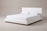 The Roccascalegna bed in white boucle with a white mattress and pillows (not included), three-quarter view on a light studio backdrop