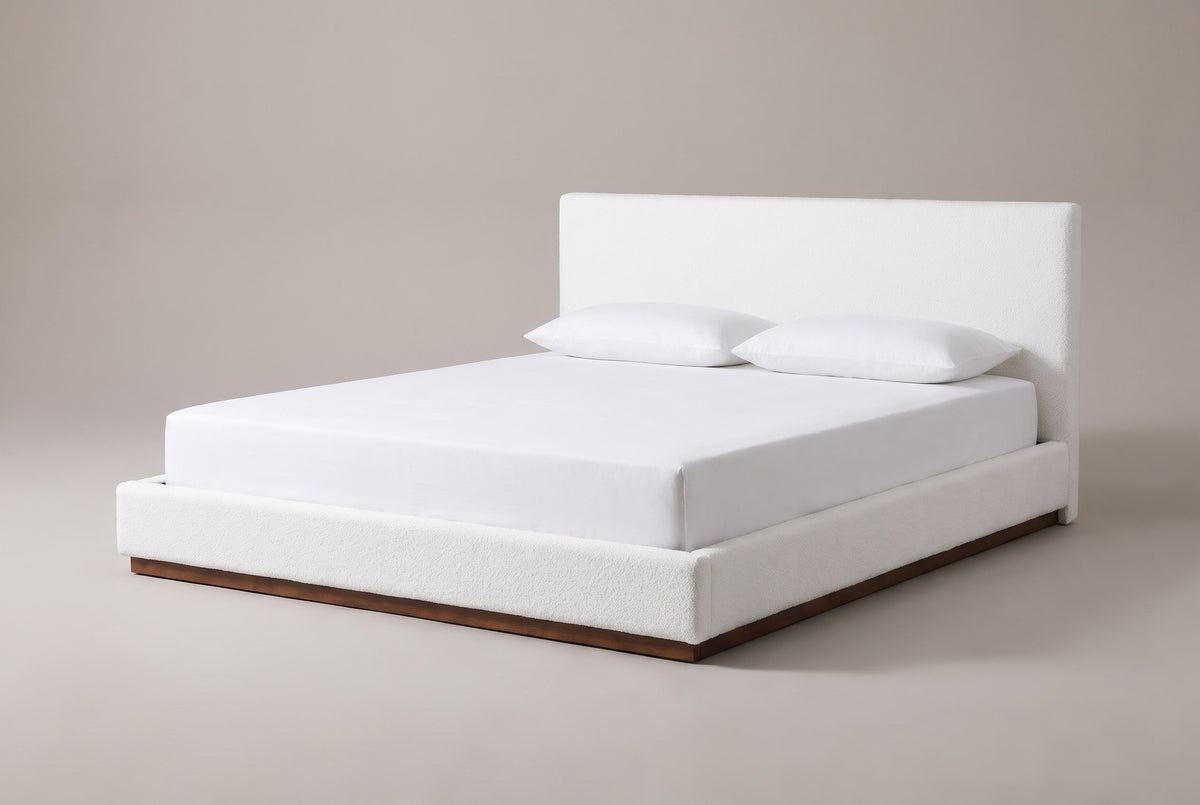 The Roccascalegna bed in white boucle with a white mattress and pillows (not included), three-quarter view on a light studio backdrop