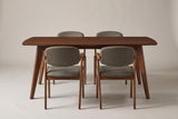 The Rossano dining set from the front: a walnut-veneer table with two chairs on each long side, on a light studio backdrop