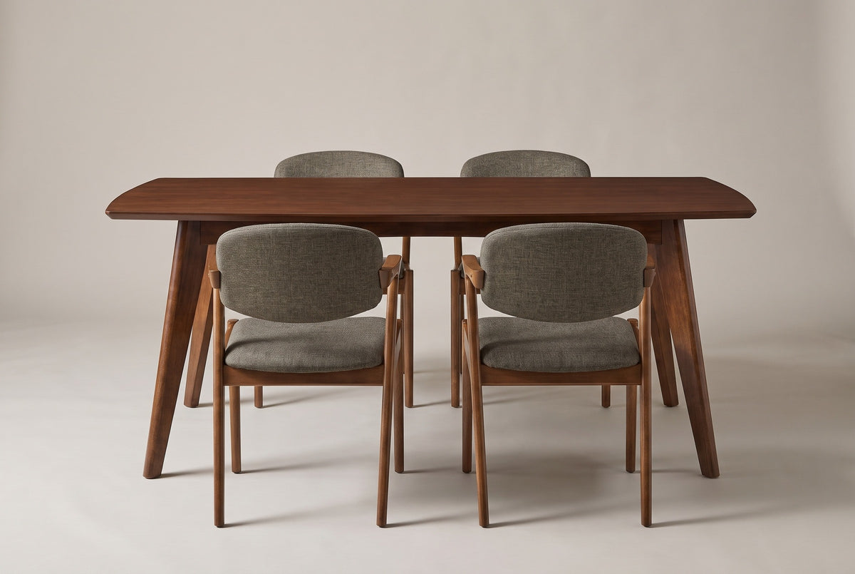 The Rossano dining set from the front: a walnut-veneer table with two chairs on each long side, on a light studio backdrop
