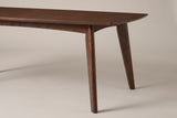 The end of the Rossano table: the thin bevelled top, the shallow arched rail and a round tapered walnut-finished leg splaying outward to the floor