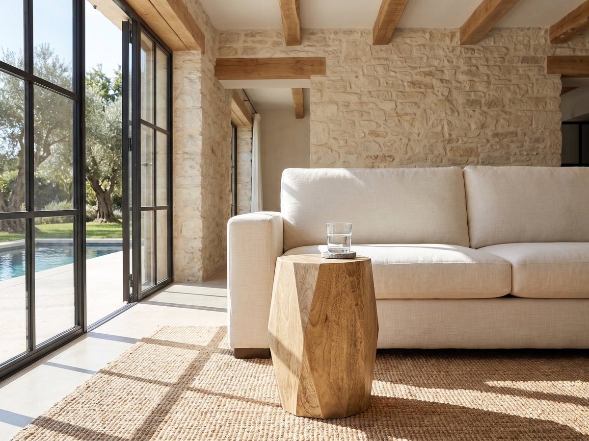 Rotondella Faceted Mango Drum Side Table beside a linen sofa in a poolside villa