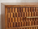 Close-up of the Rovigo 33-Inch Chestnut Carved Mango 3-Drawer Chest: the hand-carved block front of a drawer with its slim brass bar pull