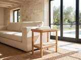 Rutigliano Braided Rattan Two-Tier Side Table beside a linen sofa in a poolside villa