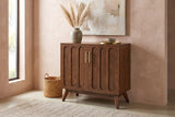 Ruvo walnut-finish cabinet with a pampas vase against a clay-pink limewash wall in an Austin entryway with a concrete floor