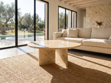 Salina Gold Beige Marble Coffee Table on a jute rug in front of a linen sofa in a poolside villa