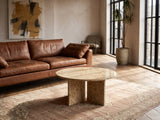 Salina Gold Beige Marble Coffee Table on a vintage rug in front of a leather sofa in an industrial loft