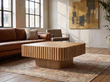Saluzzo 35-Inch Square Slatted Natural Wood Veneer Coffee Table on a vintage rug in front of a leather sofa in an industrial loft