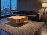 Saluzzo 35-Inch Square Slatted Natural Wood Veneer Coffee Table on a wool rug in front of a velvet sofa in a city penthouse at blue hour