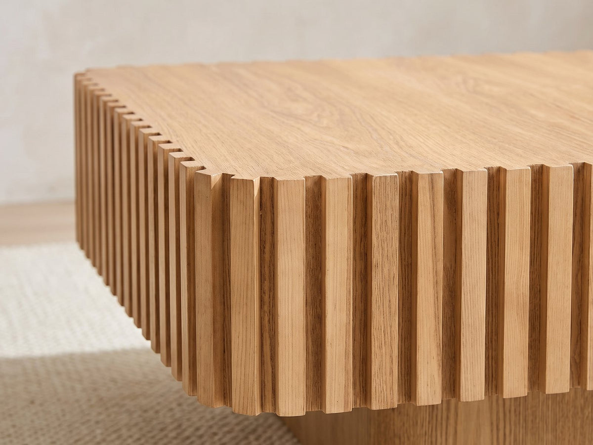 Close-up of the Saluzzo 35-Inch Square Slatted Natural Wood Veneer Coffee Table: the square-toothed edge of the top where the vertical wood slats meet it