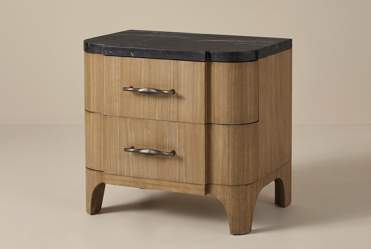 The Samassi two-drawer nightstand in honey-tan eucalyptus veneer with a black stone top, three-quarter view on a light studio backdrop