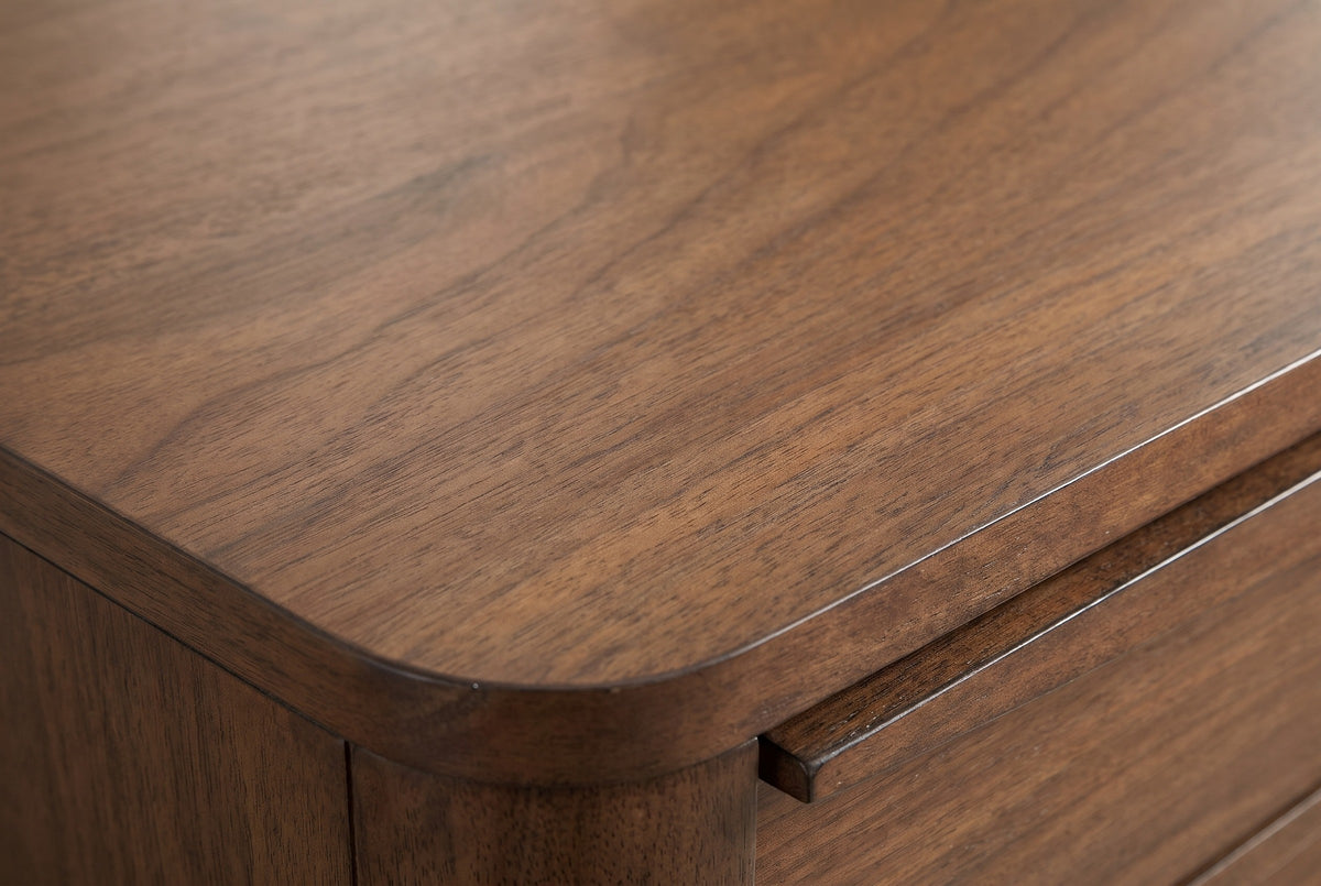 Close-up of the walnut veneer on the Sanluri nightstand: fine straight grain with darker streaks running to a rounded edge