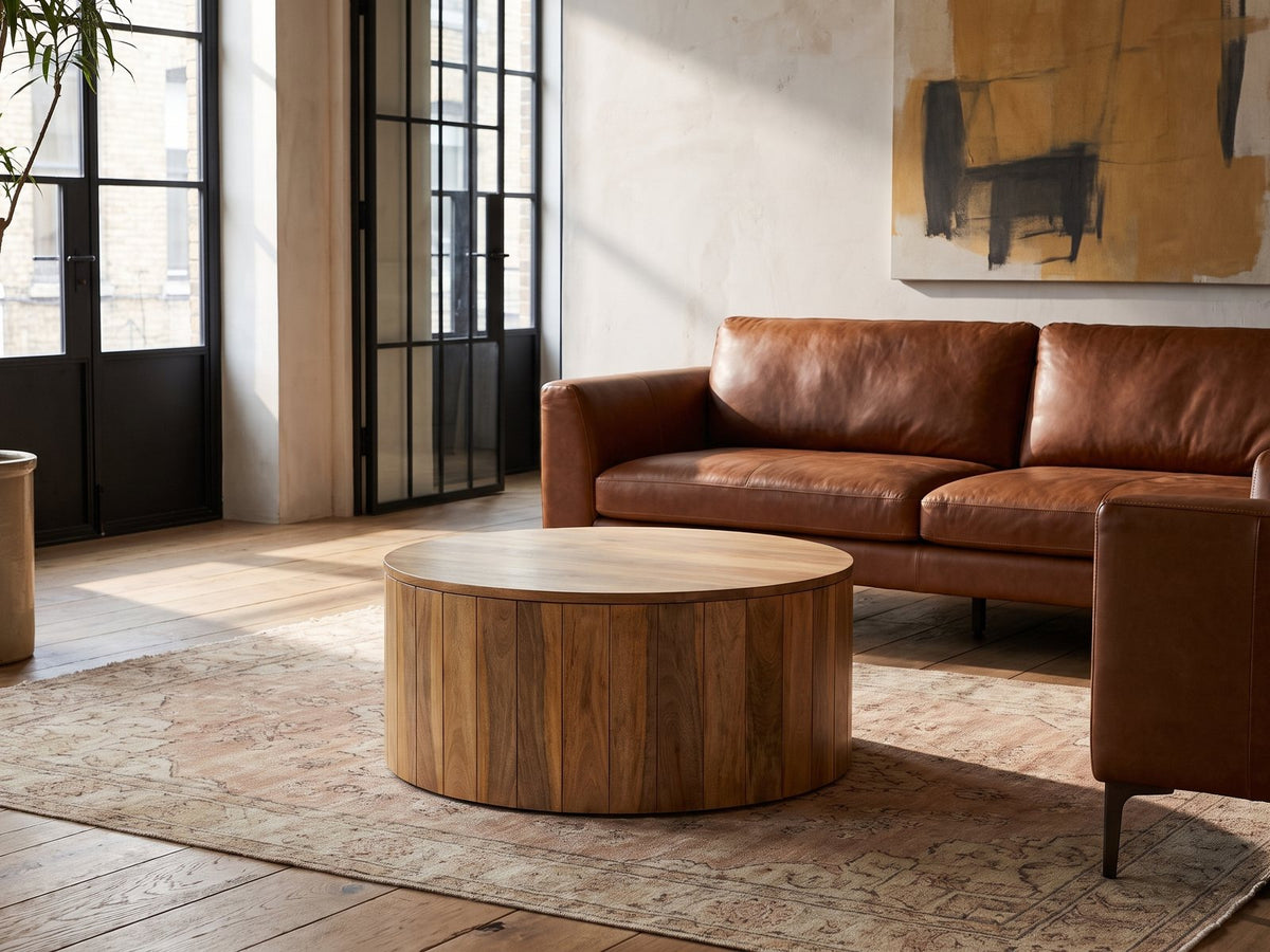 Sansepolcro Natural Mango Drum Coffee Table on a vintage rug in front of a leather sofa in an industrial loft