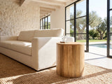 Sansepolcro Natural Mango Drum Side Table beside a linen sofa in a poolside villa