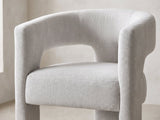 Close-up of the Saracena 54-Inch Round Ebony Oak Dining Set with 4 Boucle Chairs: the curved back and arms of a chair in light grey boucle