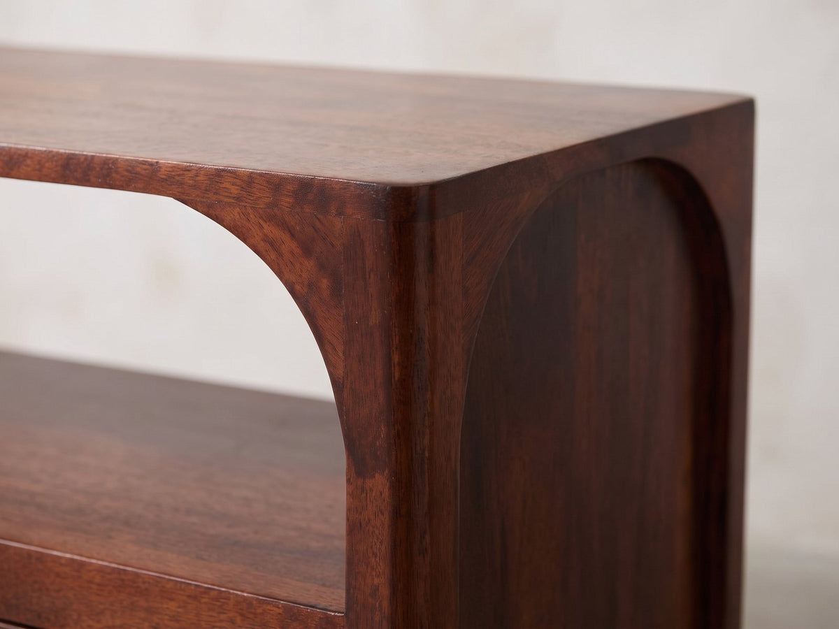 Close-up of the Sarzana 47-Inch Winewood Solid Mango Arched Media Console: the rounded top corner and the arch of the open section in solid mango