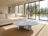 Saturnia Blue-Grey Marble Coffee Table on a jute rug in front of a linen sofa in a poolside villa