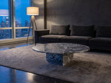 Saturnia Blue-Grey Marble Coffee Table on a wool rug in front of a velvet sofa in a city penthouse at blue hour