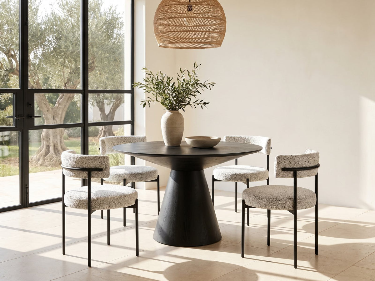 Savelli 47-Inch Round Black Oak Pedestal Dining Set with 4 Boucle Chairs in a sunlit villa dining area with olive trees outside