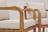 Close-up of the solid acacia on a Savoca chair: the curved arm in honey teak finish above the beige seat cushion