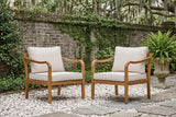Two Savoca acacia club chairs on white oyster-shell gravel in a Savannah walled garden, an old brick wall with creeping fig and live oaks behind (urn and fern not included)