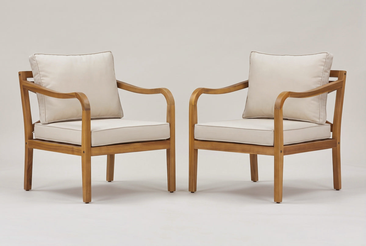 The two Savoca acacia club chairs with beige cushions, three-quarter view on a light studio backdrop
