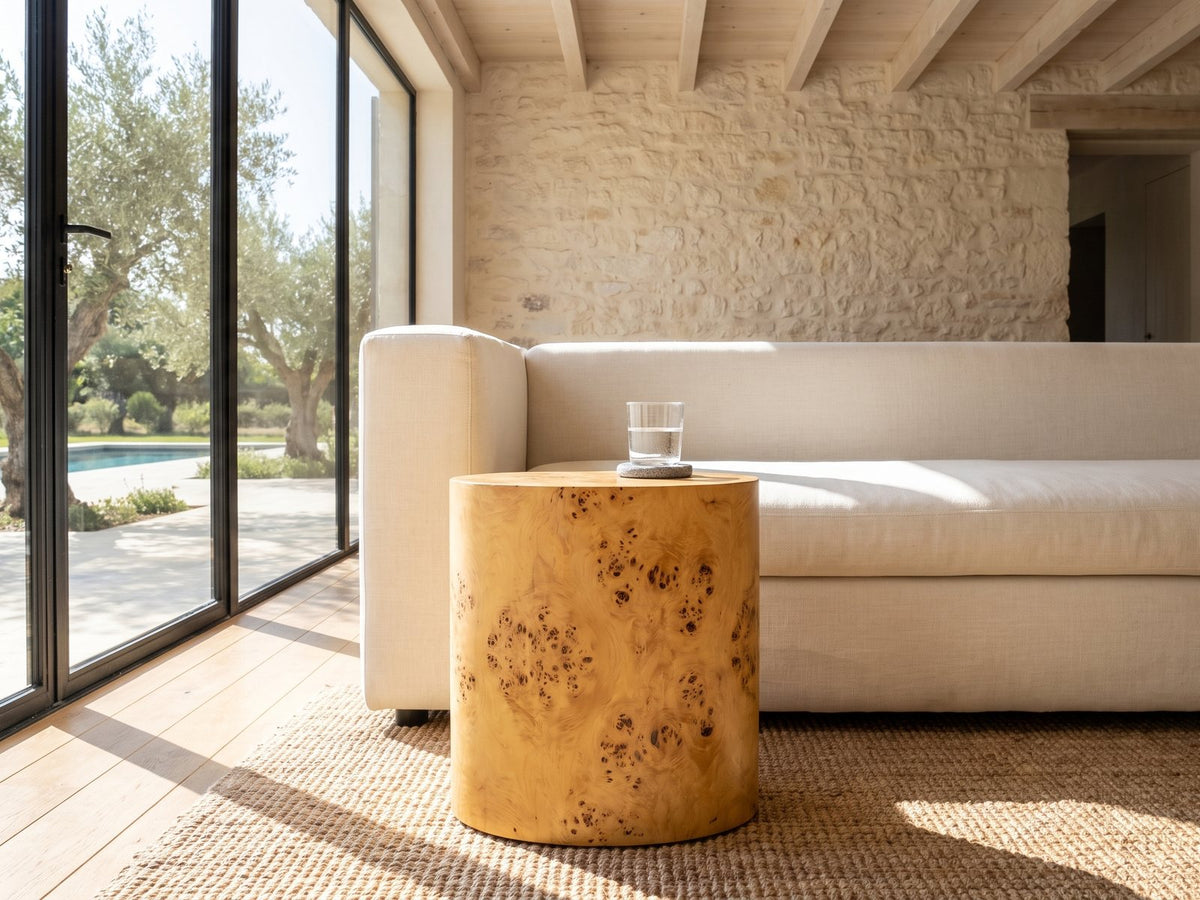 Scapoli Burl Veneer Oval Pillar Side Table beside a linen sofa in a poolside villa