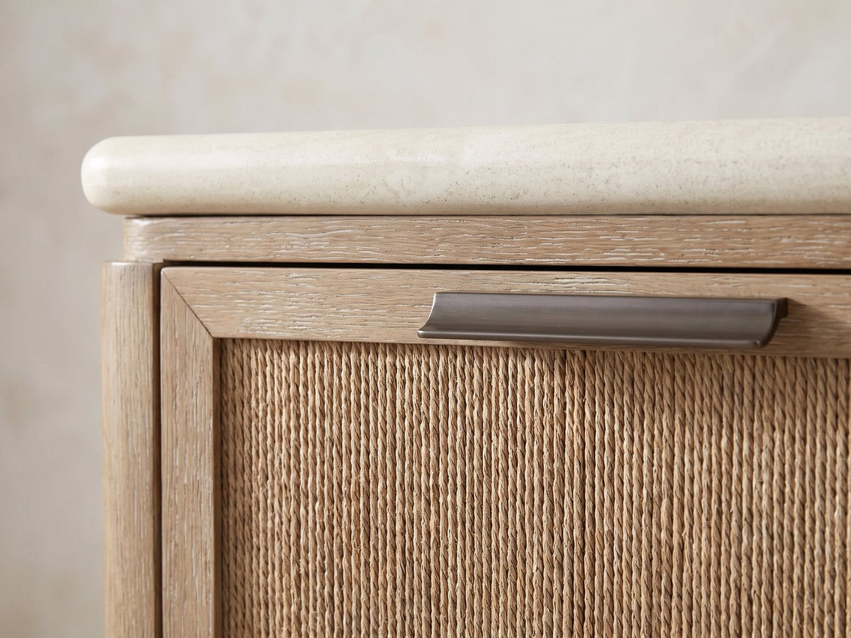 Close-up of the Schio 66.5-Inch Toffee 6-Drawer Dresser: a dark metal bar pull on the mitred oak frame of a woven rope drawer