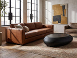 Scicli Black Fiberglass Pebble Coffee Table on a vintage rug in front of a leather sofa in an industrial loft