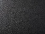 Close-up of the Scicli Black Fiberglass Pebble Coffee Table: the pebbled black finish of the fiberglass body