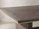 Close-up of the Scilla 75.5 to 95.5-Inch Sunburst Oak Extending Dining Set with 4 Armchairs: the sunburst oak veneer top and its thin gold-finish edge band