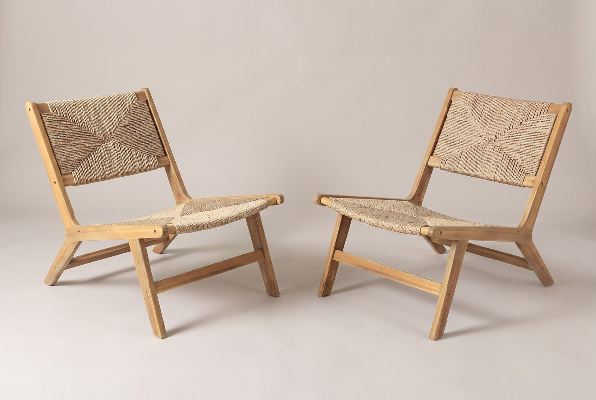 The set of two Scopello acacia and wicker lounge chairs, three-quarter view from the front on a light studio backdrop