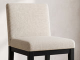 Close-up of the Sellia 59-Inch Round Ebony Cone Pedestal Dining Set with 4 Chairs: the beige upholstered back and seat of a chair on its black wood base