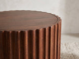 Close-up of the Senise Walnut Mango Fluted Drum Side Table: the scalloped rim of the top over the carved mango reeds
