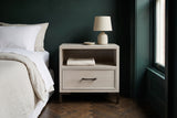 Sennori cerused oak nightstand with a ceramic lamp against a deep green wall in a Brooklyn brownstone bedroom with a herringbone floor