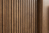 Close-up of the reeded drawer front of the Senorbi nightstand: narrow vertical ribs in warm ash brown beside the plain centre strip