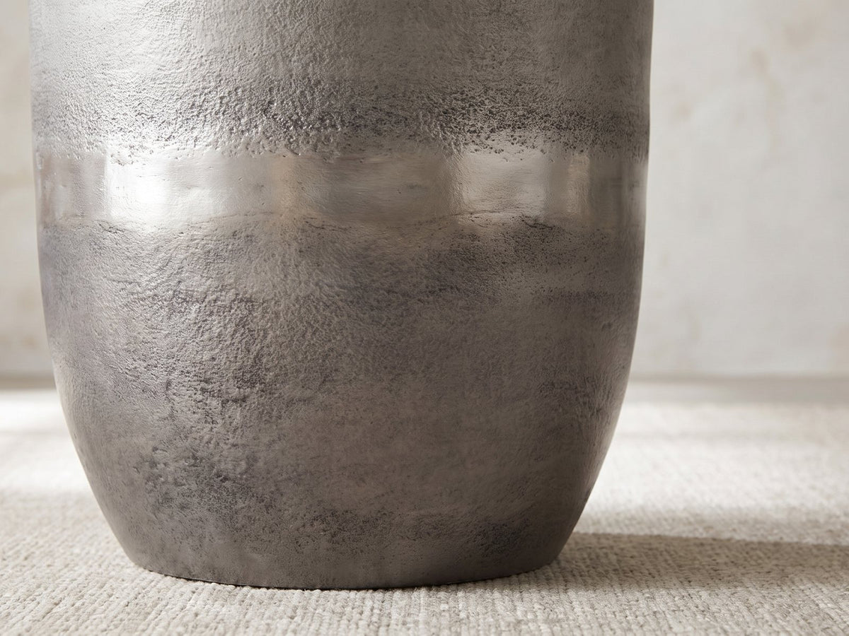 Close-up of the Sepino Antique Silver Metal Drum Side Table: the burnished band and the curve down to the foot