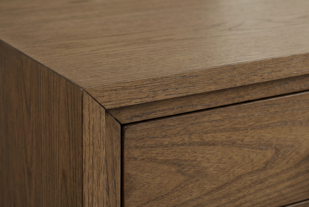 Close-up of the latte elm veneer on the Serramanna nightstand: open-pored grain at the mitred corner of the top