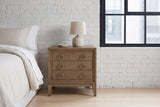 Serramanna latte elm nightstand against a white painted brick wall in a Minneapolis loft bedroom on a snowy morning