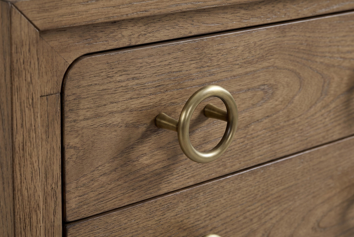 The upper drawer of the Serramanna nightstand: an antique-brass ring pull on a slim post beside the rounded drawer corner