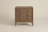 The Serramanna nightstand in latte elm with six antique-brass ring pulls, front view on a light studio backdrop