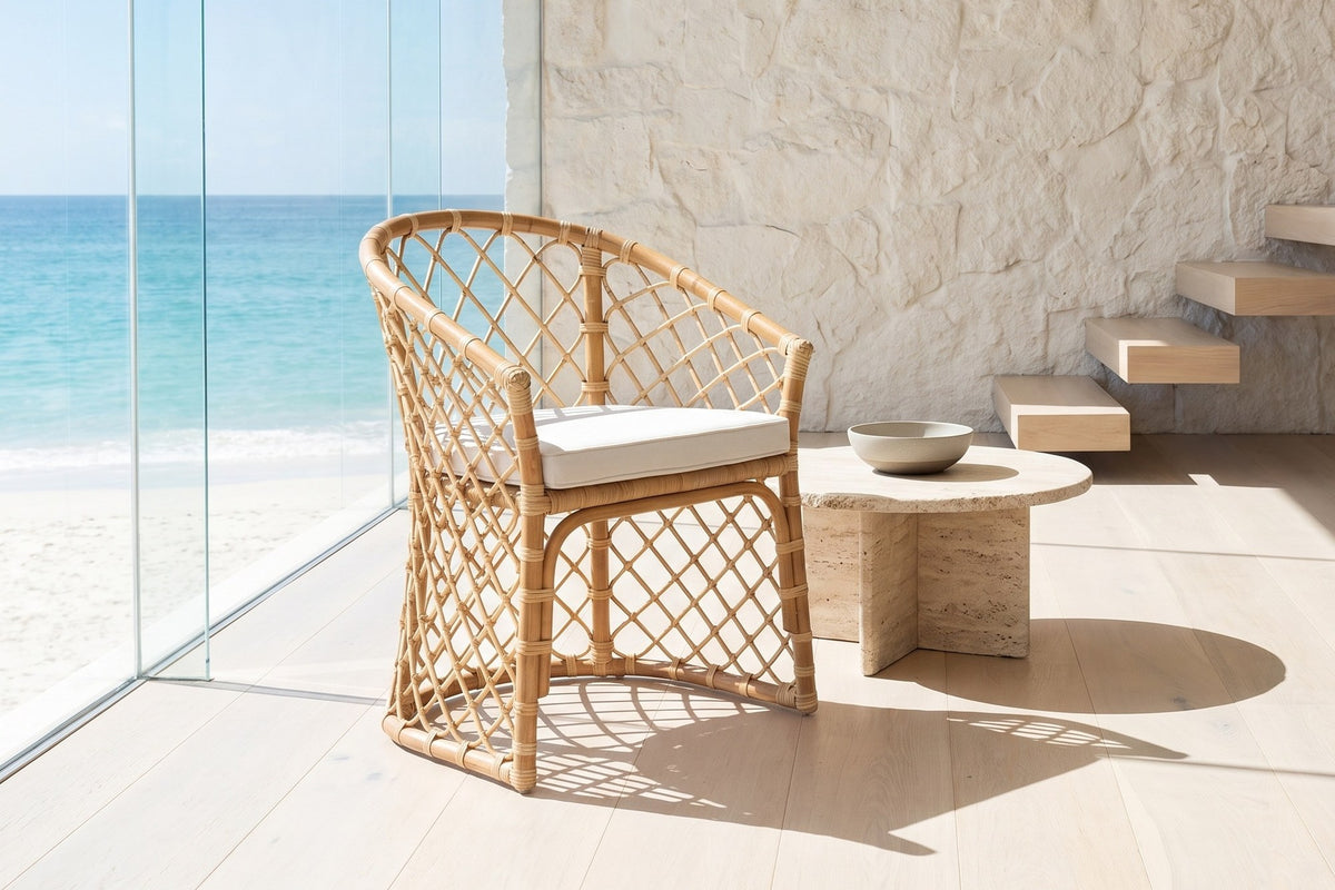 Sersale Natural Rattan Barrel-Back Dining Chair in an oceanfront glass house