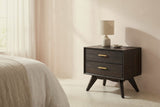 Siniscola dark acacia nightstand with a ceramic lamp beside a bed in a Palm Beach bedroom with a pale blush plaster wall and a terrazzo floor