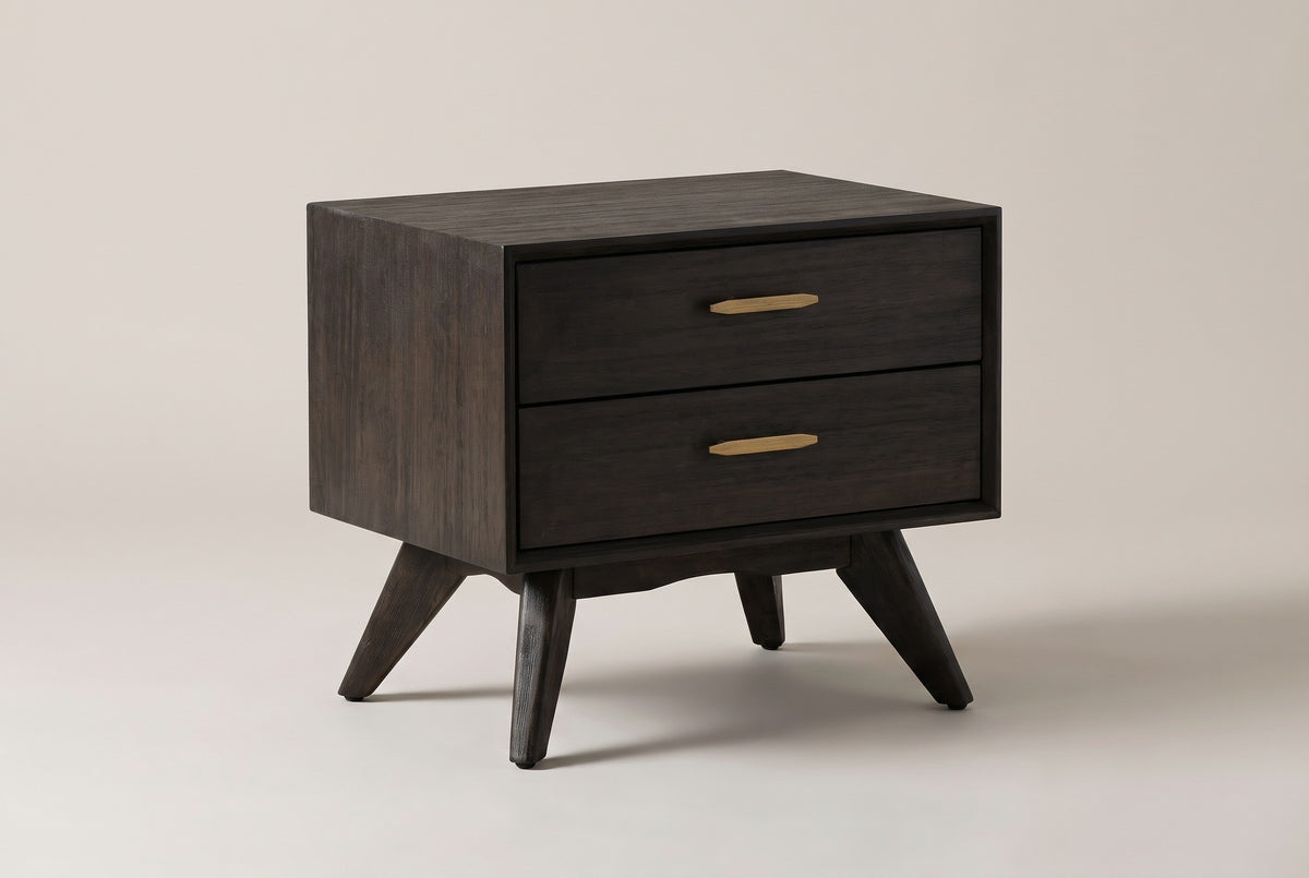 The Siniscola two-drawer nightstand in dark wire-brushed acacia with antique-brass pulls, three-quarter view on a light studio backdrop